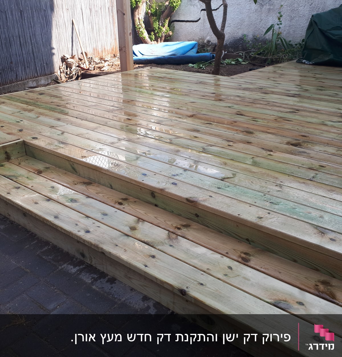 דק עץ חדש בגינה עם מדרגות קטנות